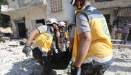 Members of the Syrian Civil Defence (White Helmets) carry away a body following a reported regime airstrike on the village of Kafriya, in Syria's Idlib province, on July 13, 2019. (AFP / Omar HAJ KADOUR)