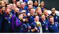 England’s captain Eoin Morgan holds the trophy as he poses with team-mates during a World Cup victory event at the Oval in London, yesterday. 