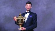 A handout picture released by the All England Lawn Tennis and Croquet Club on July 15, 2019, shows 2019 Wimbledon Men's singles champion Serbia's Novak Djokovic posing for a photograph with his trophy at the Champions Dinner on July 14, 2019 in central Lo