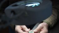 An archaeologist, Hungarian Ferenc Redo examines a metal coin of a Holocaust victim's collection in the Balatoni Museum in the town of Keszthely, 200 km west of Budapest on May 22, 2019. AFP/Attila Kisbenedek