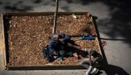 Two homeless men drink on the pavement in Paris on September 14, 2018. AFP/Joel Saget