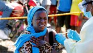 A young woman reacts as a health worker injects her with the Ebola vaccine, in Goma, Democratic Republic of Congo, August 5, 2019. REUTERS/Baz Ratner/File Photo
