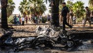 People and security forces gather at the scene of a car bomb explosion in the Kurdish-majority city of Qamishli in northeastern Syria's Hasakeh province on August 18, 2019.   AFP / Delil SOULEIMAN
