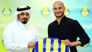 Al Gharafa’s new signing, Algerian star Adlene Guedioura (right) holding a team jersey with a club official during a press conference yesterday.