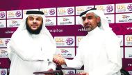Yousuf Al Awadhi, Vice-Chairman of Rehlaty Travel & Tourism company exchanging sponsorship documents with Al Kuwari, Executive Director of Marketing, Sales and Communication at QSL.
