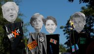 Protesters hold cutout portraits of Britain's Prime Minister Boris Johnson, German Chancellor Angela Merkel, Canada’s Prime Minister Justin Trudeau and French President Emmanuel Macron during an anti-G7 protest march on the French-Spanish border, in Henda