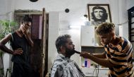 A barber cuts a client beard in a barbershop of Havana, on August 7, 2019.  AFP / Yamil Lage
 

