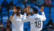 Ravindra Jadeja (L) and Virat Kohli (R) of India celebrate the dismissal of Sharmarh Brooks of West Indies during day 2 of the 1st Test between West Indies and India at Vivian Richards Cricket Stadium in North Sound, Antigua and Barbuda, on August 23, 201