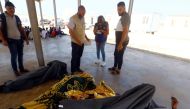 The bodies of rescued migrants are covered after being recovered and brought back to a Coast Guard Point at Al-Khums on August 27, 2019, after they were saved off the coast of Al-Khums, 100 kilometers east of the Libyan capital. AFP / Mahmud TURKIA
