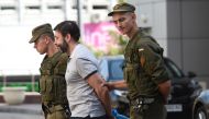 FILE PHOTO: Servicemen of the Ukrainian National Guard escort Ukrainian-Russian journalist Kyrylo Vyshynsky after his Kiev's Appeal Court hearing, in Kiev. AFP / Sergei SUPINSKY