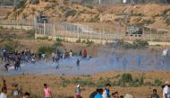 Palestinian protesters flee from tear gas fired by Israeli forces across the fence during clashes along the border with Israel near Bureij in the central Gaza Strip on August 30, 2019. AFP / Mohammed Abed 