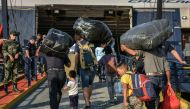 Refugees and migrants board a ship at the port of Mytilene, on the island of Lesbos on September 2, 2019, as hundreds of migrants leave Lesbos, helping to ease overcrowding at the Moria camp. AFP / STRINGER