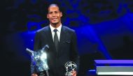  Liverpool's Dutch defender Virgil van Dijk poses with his trophies of Best Men's player in Europe of the Year and Best Defender at the end of the UEFA Champions League football group stage draw ceremony in Monaco on August 29, 2019.  AFP / Valery Hache