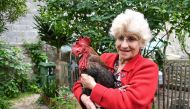 (FILES) In this file photo taken on June 5, 2019 Corinne Fesseau poses with her rooster 