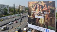 Indian commuters pass a poster advertising ‘Facebook Live What You Love’ campaign in Bangalore on March 22, 2018. AFP/Manjunath Kiran