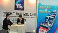 Men sit at a booth of China Export and Credit Insurance Corp, known as Sinosure, at the regional trade fair East China Fair in Shanghai, March 1, 2013. Reuters