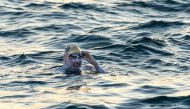 A handout photograph taken off the coast of Dover, southern England on September 15, 2019, and released by Jon Washer Photoraphy on September 17, 2019 shows US swimmer Sarah Thomas swimming in the Dover Strait, 10 miles off the English coast, on the first