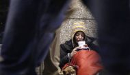 A homeless woman from north Wales sits huddled under a sleeping bag next to her dog in a shopping arcade near the Victoria rail station in London, December 14, 2012. Reuters/Chris Helgren