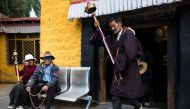 A pilgrim spinning his prayer wheel in front of the Thousand Buddha Cliffside Sculpture on September 10, 2016 in the regional capital Lhasa in Tibet Autonomous Region of China. (AFP / Johannes Eisele) 