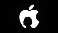 A reporter walk by an Apple logo during a media event in San Francisco, September 9, 2015. AFP/Josh Edelson