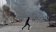An Iraqi protester runs amidst clashes during a demonstration against state corruption, failing public services, and unemployment in the Iraqi capital Baghdad's central Khellani Square on October 4, 2019. / AFP / AHMAD AL-RUBAYE
