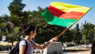 A young girl waves the flag of Kurdistan during a demonstration by Syrian Kurds against Turkish threats to launch a military operation on their region, in the town of Al-Qahtaniyah, in northeastern Syrian Al-Hasakah Governorate on October 7, 2019. AFP / D