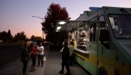 Local residents pick up meals from El Coyote food truck, one of the few food trucks open in the area, in Sonoma, California, on October 9, 2019, after the Pacific Gas & Electric (PG&E) utility company began planned power outages. AFP / Brittany Hosea-Smal