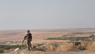 A Turkish soldier overlooks the border with Syria on Ocotber 13, 2019 near the Turkish city of Ceylanpinar as fighting rages in the Syrian border town of Ras al-Ain on the fifth day of the Turkish offensive in Syria against the Kurdish People's Protection