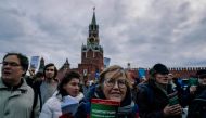 Opposition supporters holding the Russian Constitution books walk on Red Square to support opposition activist Konstantin Kotov, who was sentenced to four years in prison for repeatedly taking part in unauthorised rallies, in downtown Moscow on October 13