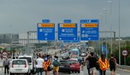 People walk on the highway towards El Prat airport in Barcelona on October 14, 2019 as thousands of angry protesters took to the streets after Spain's Supreme Court sentenced nine Catalan separatist leaders to between nine and 13 years in jail for seditio
