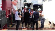 Members of Doctors Without Borders (MSF) talk to migrants onboard Ocean Viking after a rescue operation, October 13, 2019.  Julia Schaefermeyer/SOS Mediterranee via Reuters. 