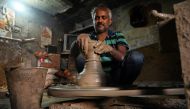 In this photograph taken on October 4, 2019, a potter makes a clay pot in his residence at Kumhar Gram (Potter's Village) in New Delhi. AFP / Money SHARMA