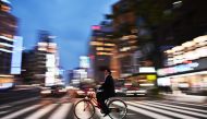 A man rides his bicycle at night in Tokyo on April 22, 2019. AFP / Charly Triballeau