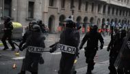 Police officers intervene in protesters during clashes near the Police headquarters in Barcelona, on October 18, 2019, on the day that separatists have called a general strike and a mass rally. (Adria Puig - Anadolu Agency)