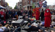 Extinction Rebellion members and those from immigrant, housing rights groups, participate in a four-minute long die-in upon arriving in Harvard Square in Cambridge, Massachusetts, at the end of the Honk! Festival march, October 13, 2019. Thomson Reuters F