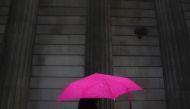 A woman carries an umbrella during a rain shower as she walks past the Bank of England in London, November 30, 2009. Reuters / Andrew Winning