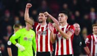 Sheffield United's English defender Chris Basham (L) and Sheffield United's Irish defender John Egan (R) celebrate on the pitch after the English Premier League football match between Sheffield United and Arsenal at Bramall Lane in Sheffield, northern Eng