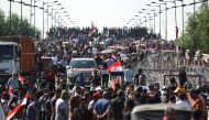 Iraqi protesters gather on the capital Baghdad's Al-Jumhuriyah Bridge on October 26, 2019, during an anti-government protest. Iraqi security forces fired tear gas to clear lingering protesters in Baghdad this morning, after dozens died in a bloody resumpt