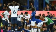 Teammates comfort Everton's Portuguese midfielder André Gomes (C floor) as he gets attention for an injury as Everton's Irish defender Seamus Coleman (R) looks on during the English Premier League football match between Everton and Tottenham Hotspur at Go