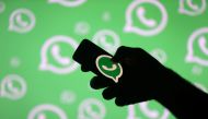 A man poses with a smartphone in front of displayed Whatsapp logo in this illustration, September 14, 2017. Reuters / Dado Ruvic