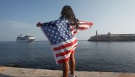 FILE PHOTO: A woman with a US flags looks at the arrival of US Carnival cruise ship Adonia at the Havana bay May 2, 2016. Reuters