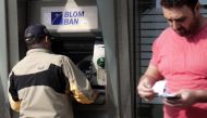 A man withdraws cqsh from an ATM machine in the Lebanese capital Beirut on November 9, 2019.  AFP / ANWAR AMRO