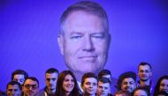 File photo of supporters of Romanian President Klaus Iohannis stand in front of his picture at an electoral meeting at the sports hall in Braila city (south-east Romania) November 6, 2019. / AFP / Daniel MIHAILESCU 