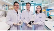 The NUS research team behind the novel algae detection device is led by Assistant Professor Bae Sung Woo (centre) who is holding the smartphone platform. With him are two team members: Mr Thio Si Kuan (left) who is holding the microfluidic chip, and Miss 