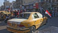Iraqis gather at the site of a bomb explosion near Baghdad's Tahrir Square on November 16, 2019.   AFP / SABAH ARAR