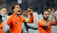 Netherlands' defender Virgil van Dijk (L) and Netherlands' defender Daley Blind (R) celebrate their qualification for the finals on the pitch after the Euro 2020 qualification football match between Northern Ireland and Netherlands at Windsor Park in Belf