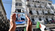 A supporters of Abdelkader Bengrina, former Algerian tourism minister and presidential candidate for the El-Bina (Construction) Islamist party, applauds outside his electoral campaign headquarters in the capital Algiers on November 17, 2019. AFP / Ryad Kr