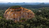 A large rock juts out from the tropical rainforest in the central African country of Gabon, 23 August 2012. Josh Ponte/Handout via Thomson Reuters Foundation