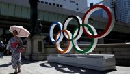 File photo of a woman wearing the yukata, or casual summer kimono, walks past Olympic rings displayed at Nihonbashi district in Tokyo, Japan August 5, 2019. REUTERS/Issei Kato/File Photo
 