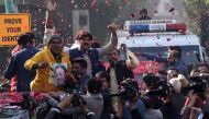 Supporters of Pakistan Muslim League Nawaz (PML-N) gather around a vehicle, covered with rose petals, carrying the ailing former Pakistani prime minister Nawaz Sharif as he travels to Lahore airport prior to his departure for abroad for medical treatment,